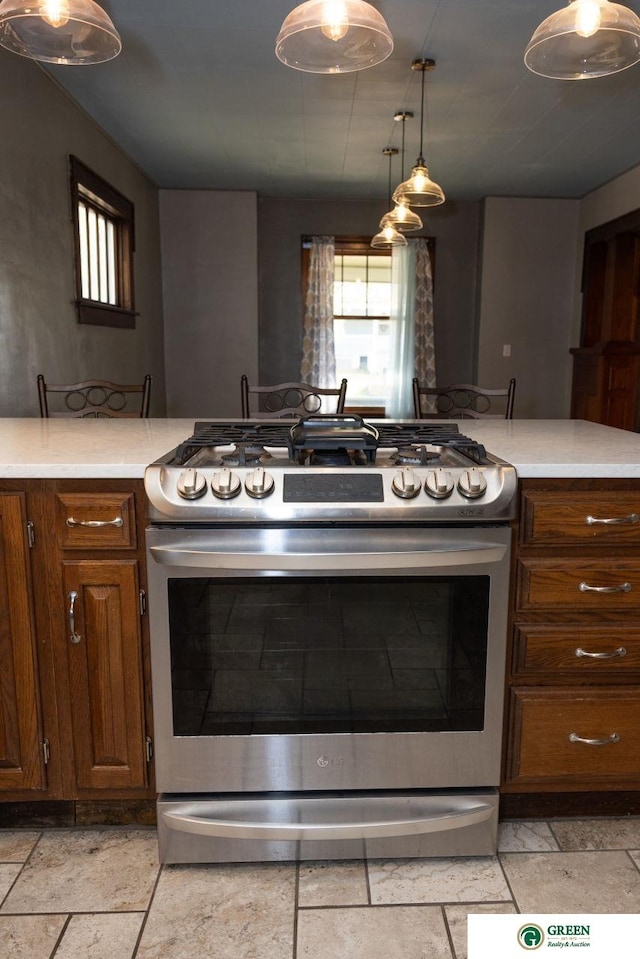 kitchen featuring stainless steel gas range oven and decorative light fixtures