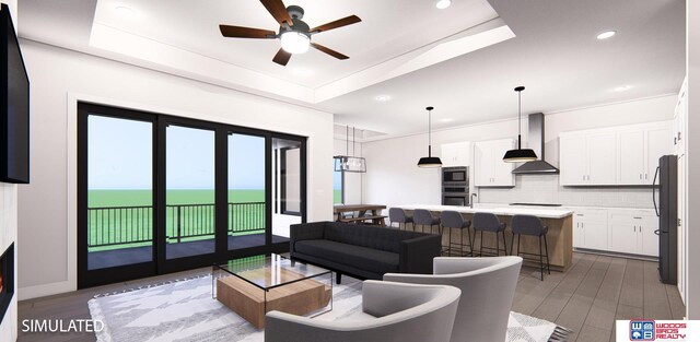 living room featuring a tray ceiling, wood-type flooring, a water view, and ceiling fan