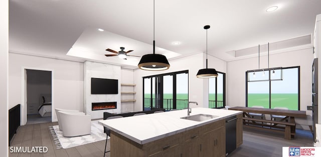 kitchen with dishwasher, dark hardwood / wood-style floors, an island with sink, sink, and a fireplace