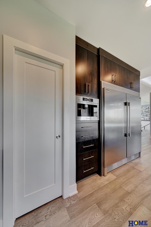 kitchen featuring light hardwood / wood-style floors, stainless steel appliances, and dark brown cabinetry