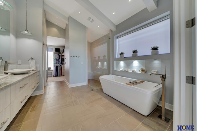 bathroom featuring vanity, lofted ceiling, and a tub to relax in