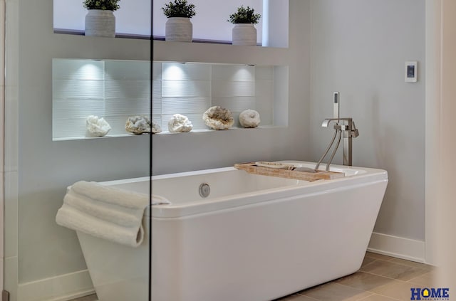 bathroom with a tub to relax in and tile patterned flooring