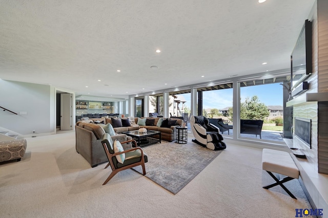 living room featuring expansive windows, light carpet, and a textured ceiling