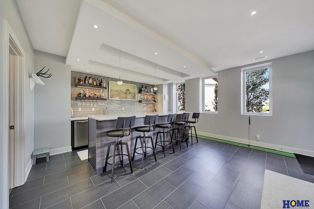 bar featuring decorative backsplash, decorative light fixtures, and dishwasher