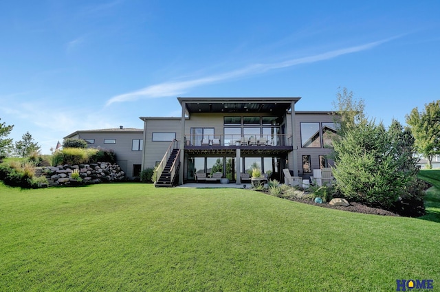 rear view of property featuring a patio area, a deck, and a lawn