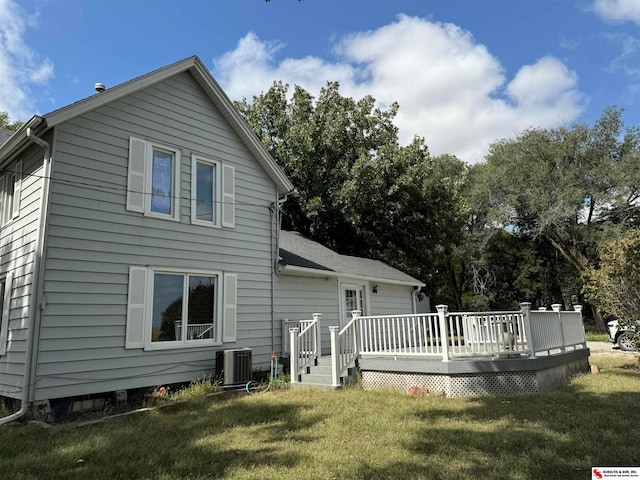 back of property with a yard and a wooden deck