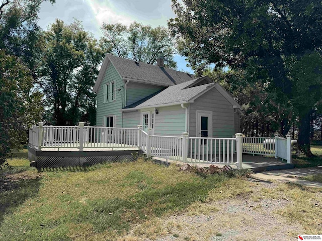 back of property featuring a yard and a wooden deck