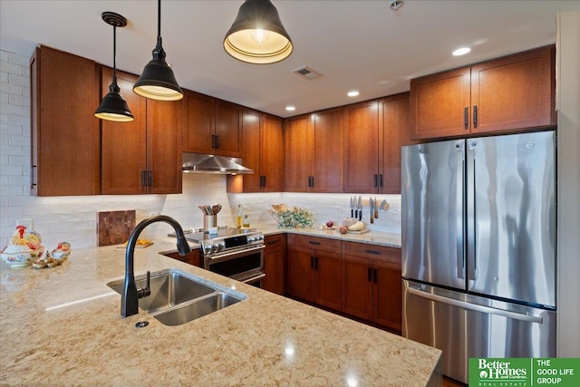 kitchen featuring sink, appliances with stainless steel finishes, light stone countertops, hanging light fixtures, and decorative backsplash