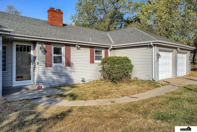 view of side of property with a garage and a lawn