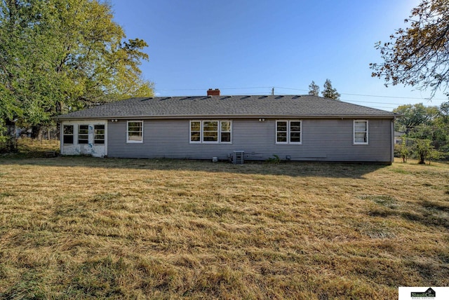 rear view of property featuring a lawn