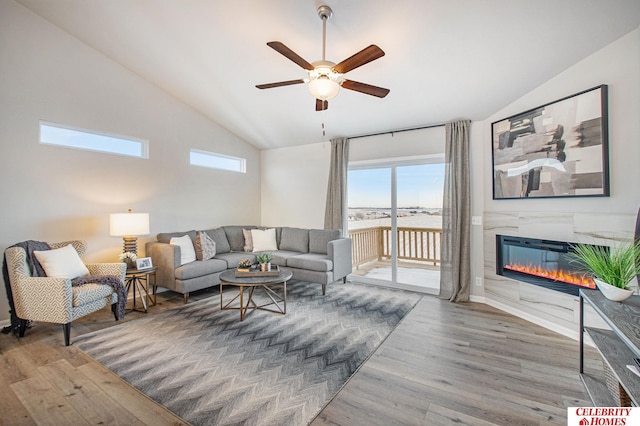 living room with hardwood / wood-style floors, ceiling fan, and vaulted ceiling