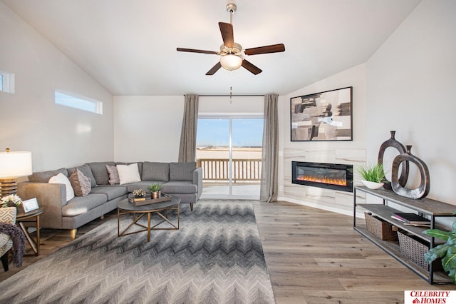 living room featuring ceiling fan, wood-type flooring, and vaulted ceiling