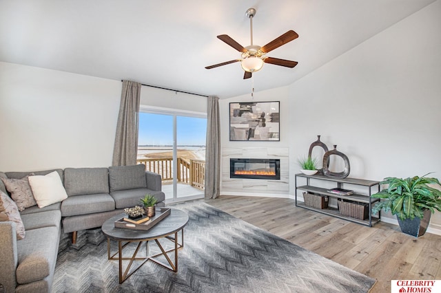 living room with hardwood / wood-style floors, ceiling fan, and vaulted ceiling