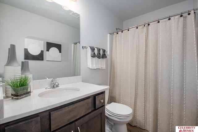 bathroom with toilet, vanity, and wood-type flooring