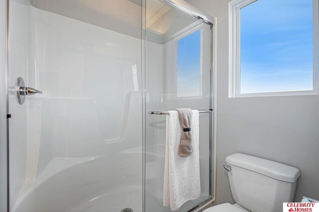 bathroom with toilet and an enclosed shower