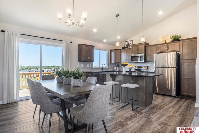 dining space featuring high vaulted ceiling, a wealth of natural light, and dark hardwood / wood-style flooring