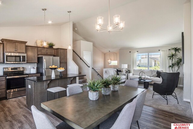 dining area with a notable chandelier, high vaulted ceiling, and dark hardwood / wood-style flooring