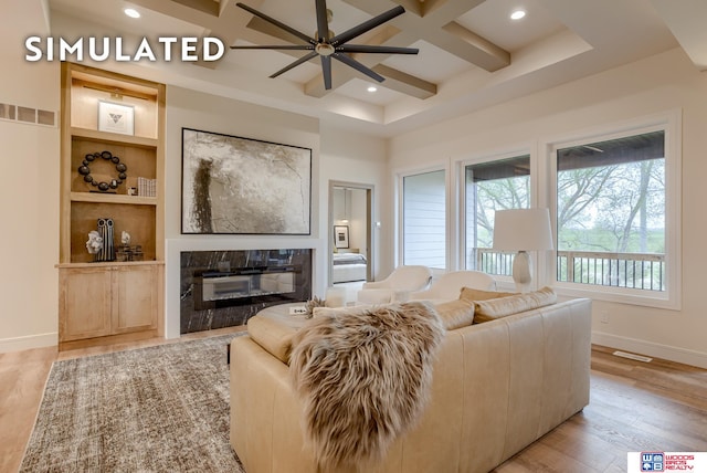 living room featuring beam ceiling, ceiling fan, light hardwood / wood-style flooring, a fireplace, and coffered ceiling