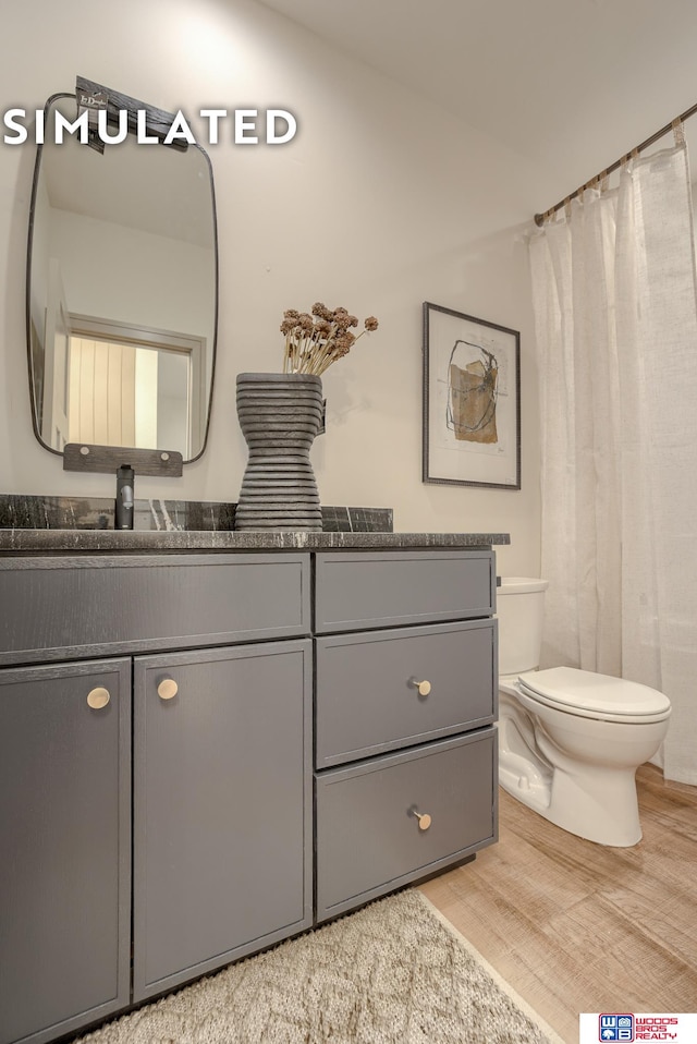 bathroom featuring lofted ceiling, hardwood / wood-style flooring, toilet, vanity, and a shower with curtain