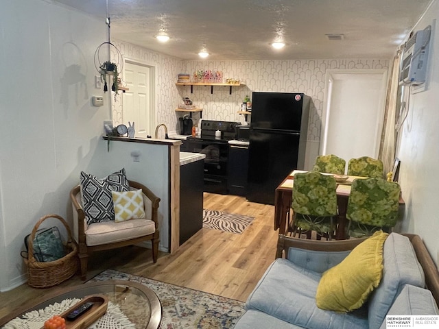 interior space featuring wood-type flooring and black fridge