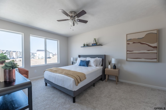 carpeted bedroom with a ceiling fan and baseboards