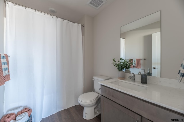 bathroom featuring visible vents, wood finished floors, toilet, and vanity