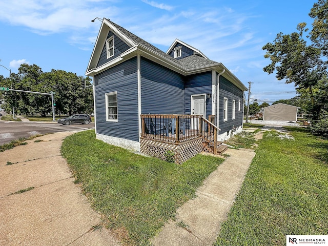 view of side of property featuring a wooden deck and a yard