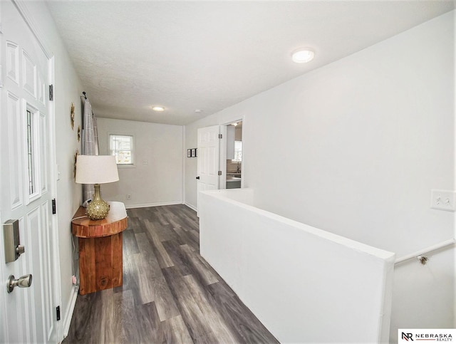 corridor featuring a textured ceiling and dark hardwood / wood-style floors