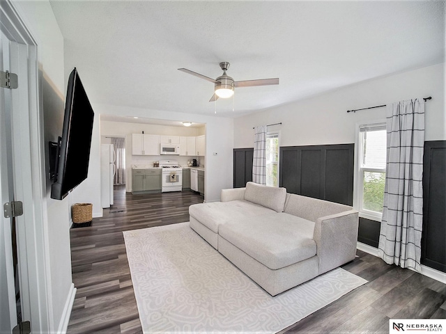 living room featuring dark hardwood / wood-style floors and ceiling fan