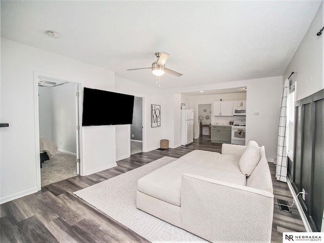 living room with dark wood-type flooring and ceiling fan