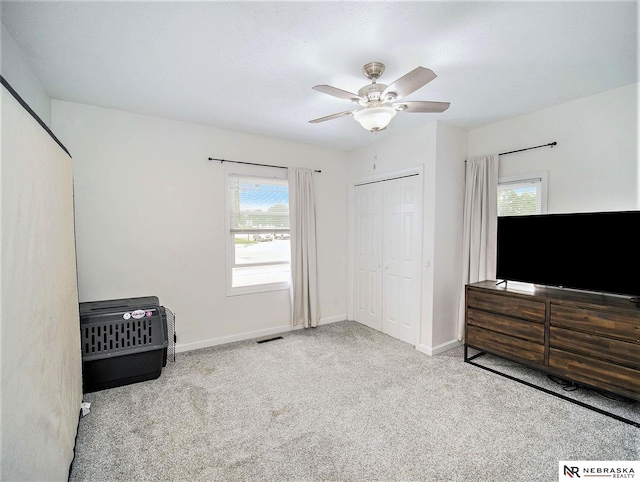 carpeted bedroom featuring a closet and ceiling fan