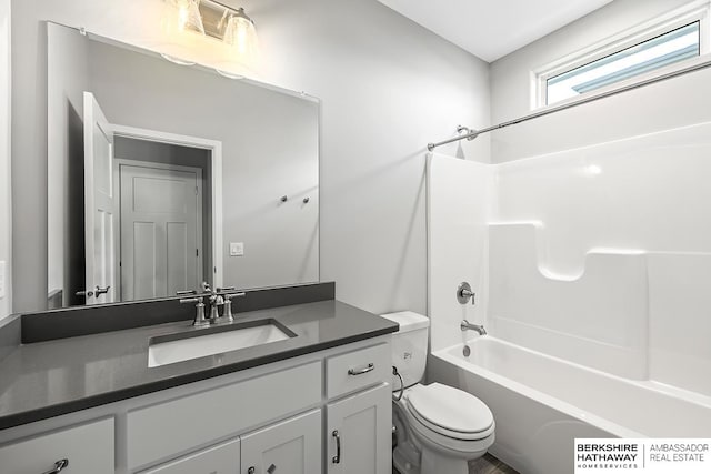 full bathroom featuring toilet, vanity, and tub / shower combination