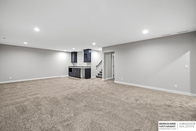 basement featuring bar and carpet flooring