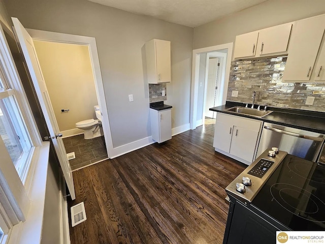 kitchen featuring white cabinetry, sink, dark wood-type flooring, and backsplash