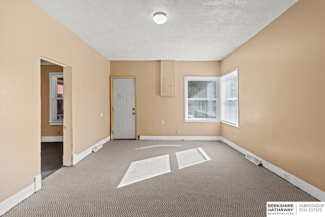 unfurnished room featuring a textured ceiling and light colored carpet