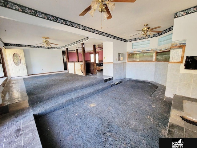 interior space featuring tile walls and ceiling fan