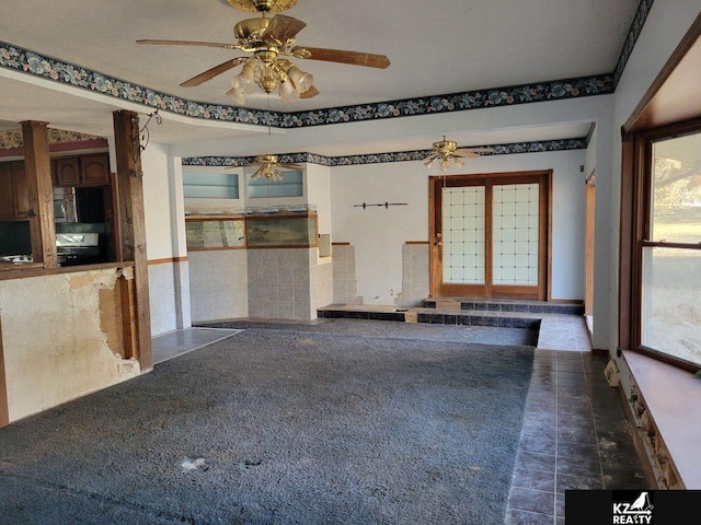 spare room with tile walls and ceiling fan