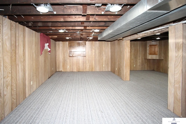 basement with wood walls and light colored carpet