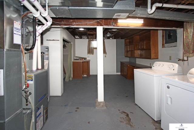 basement with electric panel, washing machine and dryer, and heating unit