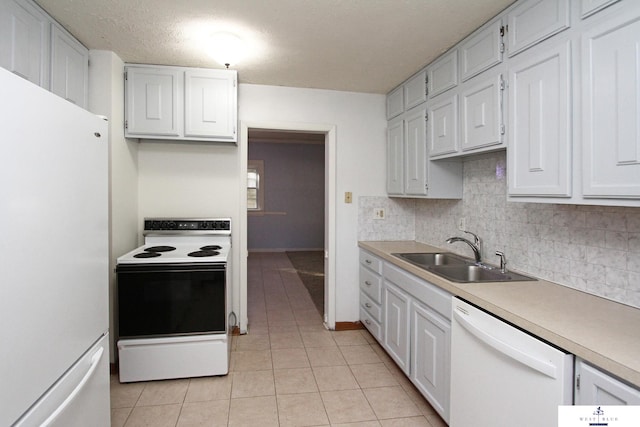 kitchen featuring white cabinets, sink, light tile patterned floors, and white appliances