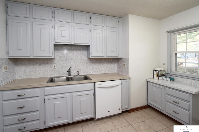 kitchen with light tile patterned flooring, decorative backsplash, dishwasher, and sink