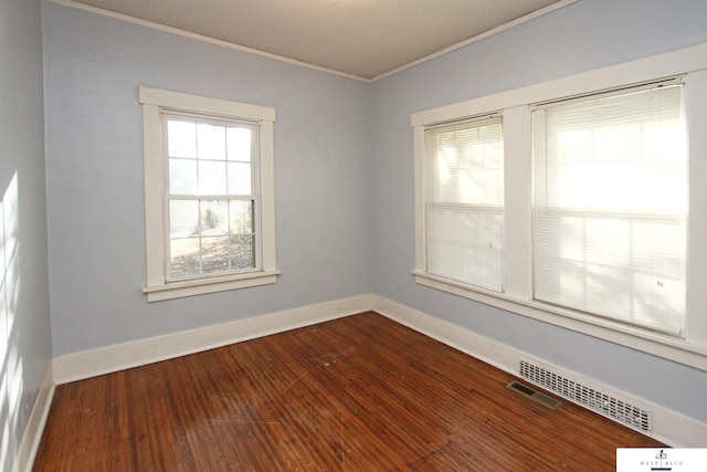 spare room with ornamental molding and hardwood / wood-style flooring