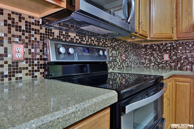 kitchen featuring black electric range oven and tasteful backsplash