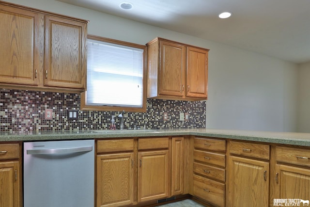 kitchen featuring stainless steel dishwasher, sink, and backsplash