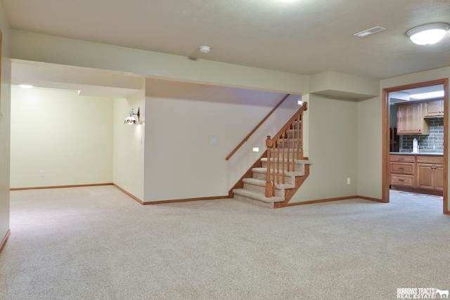 interior space with light carpet and a textured ceiling