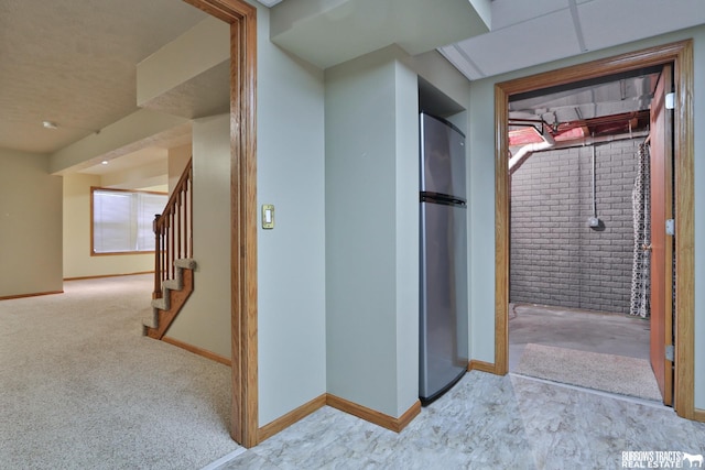 hallway with brick wall and light carpet