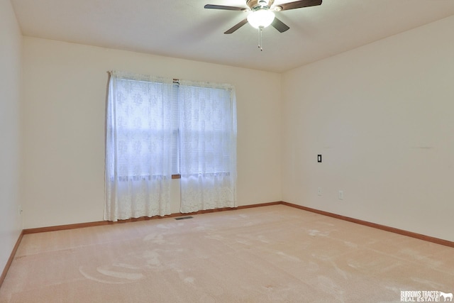 carpeted spare room featuring ceiling fan