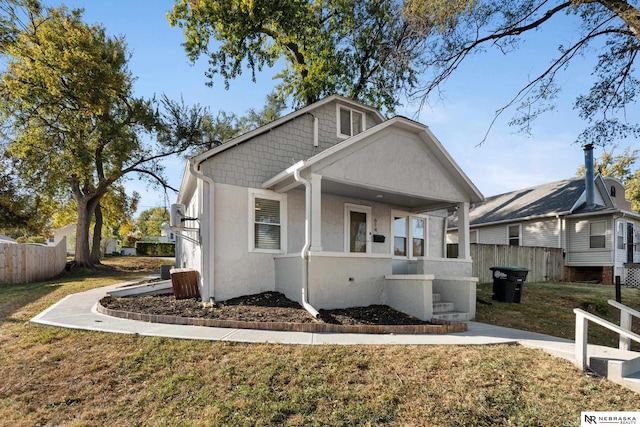 view of front of property featuring covered porch and a front lawn