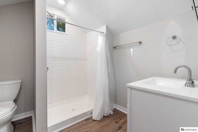 bathroom with curtained shower, toilet, vaulted ceiling, vanity, and hardwood / wood-style flooring