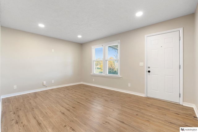 foyer with light hardwood / wood-style flooring and a textured ceiling